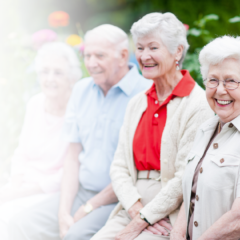 Four smiling seniors enjoying outdoor spring activities at a senior living community