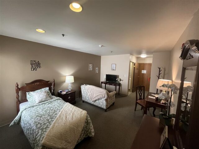 bed, bedroom set and couch in a delxue room at devonhouse